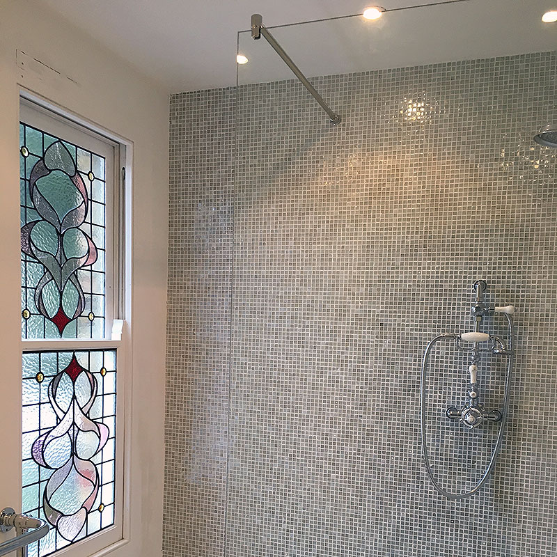 Frameless glass shower suspended from ceiling rail