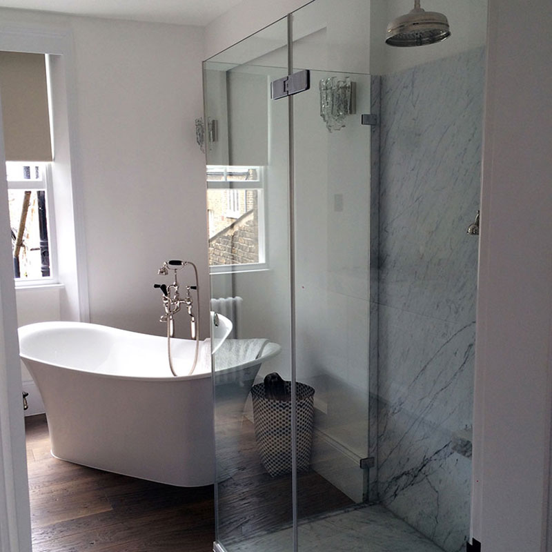 Frameless Glass Shower beside a bath