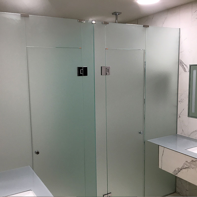 Frosted glass bathroom cubicles with doors closed