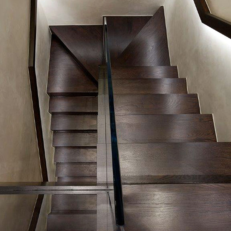 Glass balustrade on dark wood interior staircase