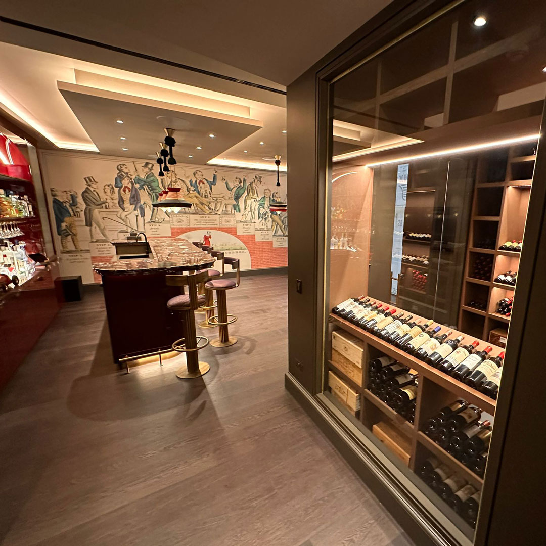 A bespoke glass wine cooler in a luxury home bar setting