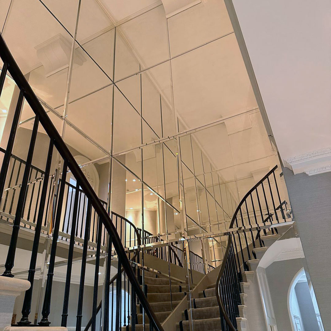 A wall of bespoke square mirrors covering the wall of a stairwell in Richmond